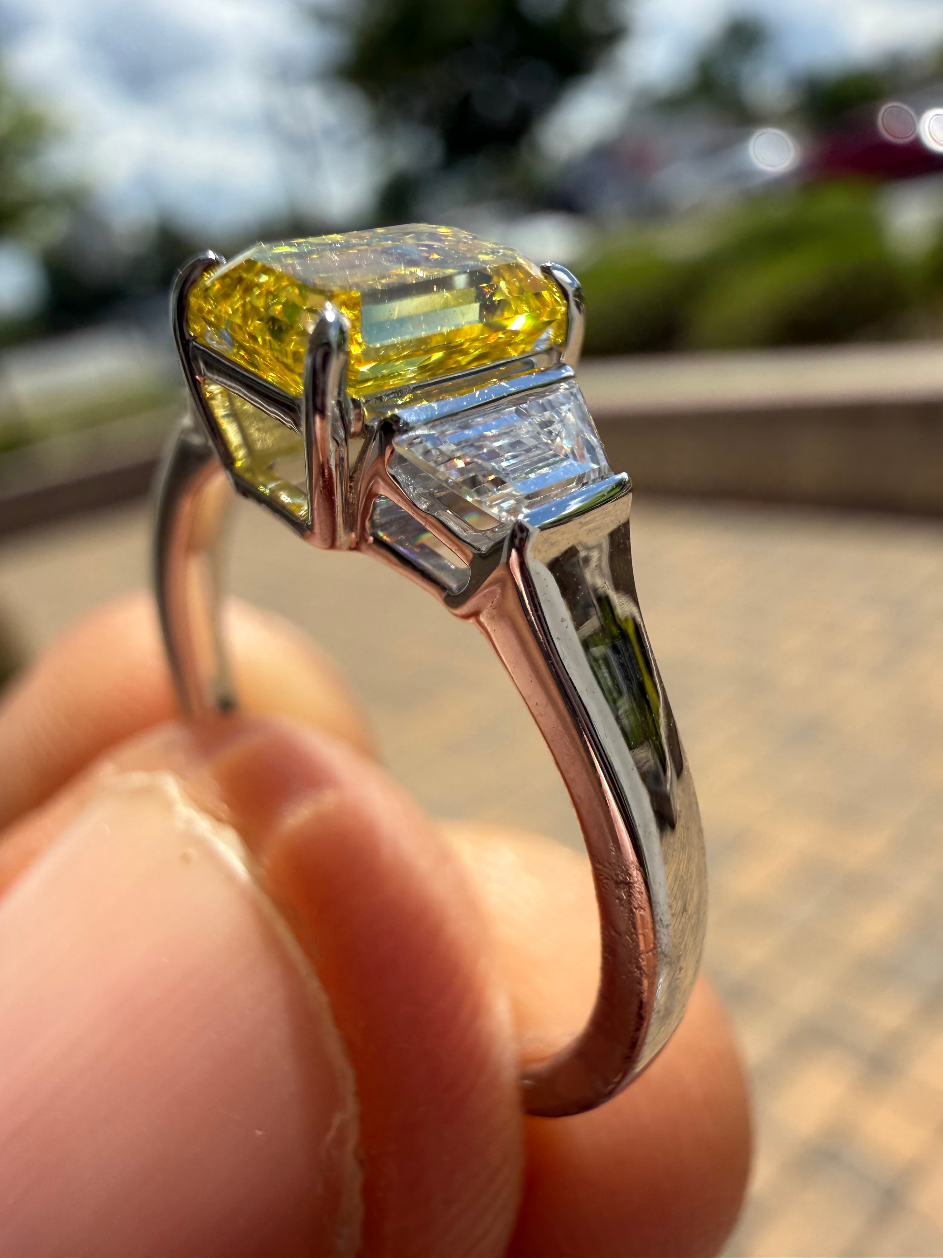 1.5 carat  Emerald cut center stone fancy yellow emerald cut ring in fancy vivid yellow igi certified VS stone with special cut side stones on side handcrafted in color high cut with  handcrafted ring made with 14k gold in grown diamond igi certified