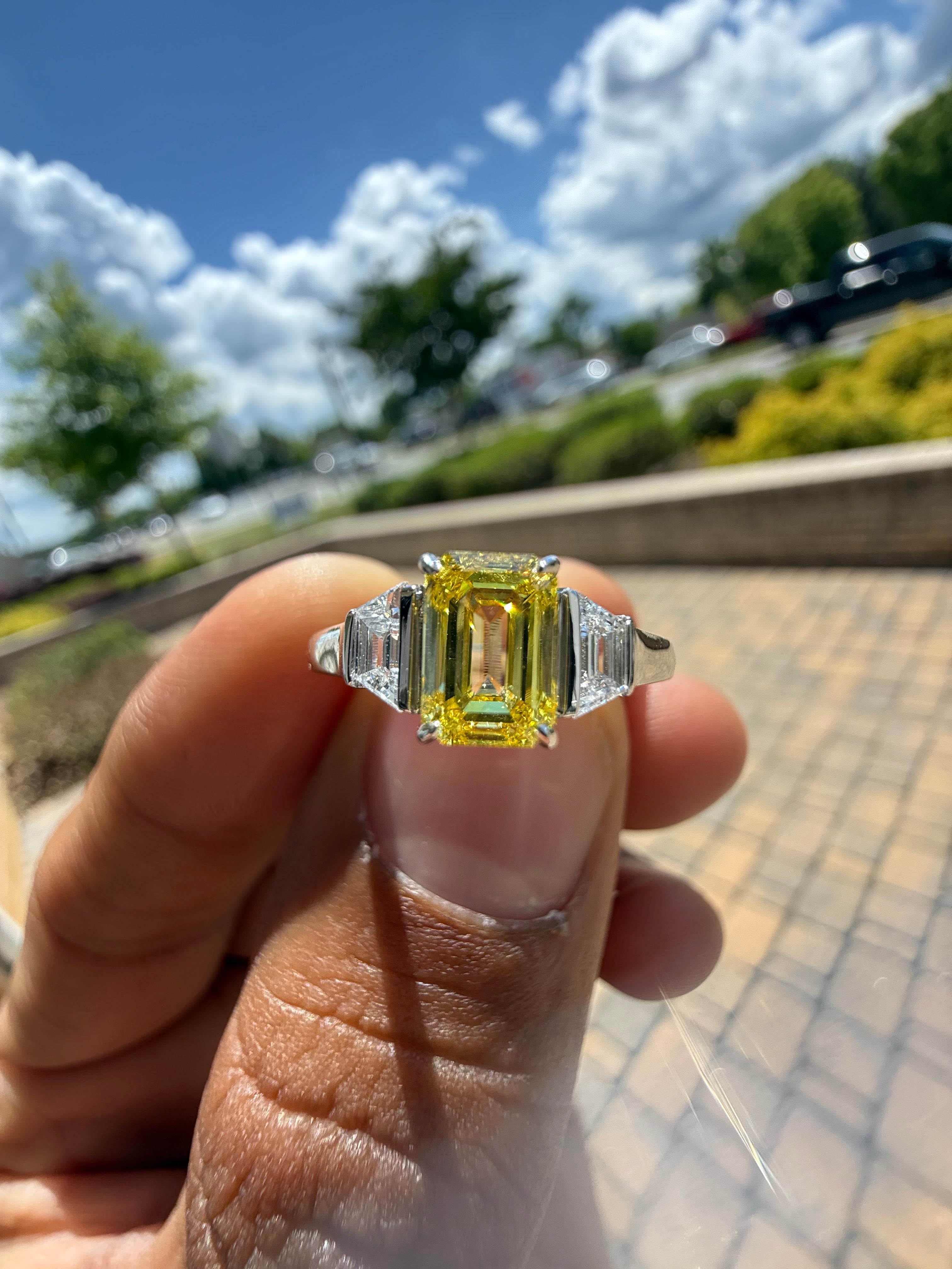 1.5 carat  Emerald cut center stone fancy yellow emerald cut ring in fancy vivid yellow igi certified VS stone with special cut side stones on side handcrafted in color high cut with  handcrafted ring made with 14k gold in grown diamond igi certified